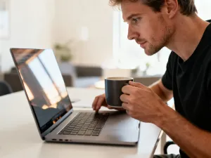 Zaniepokojony mężczyzna naprawia komputer z niebieskim ekranem błędu systemu Windows 10 przy użyciu narzędzi i dysku USB.